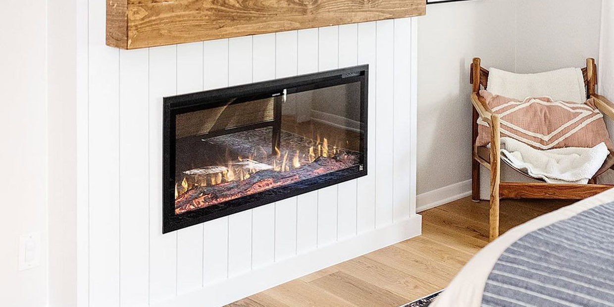 Touchstone Sideline Elite Electric Fireplace in white shiplap wall with reclaimed wood mantel in the bedroom