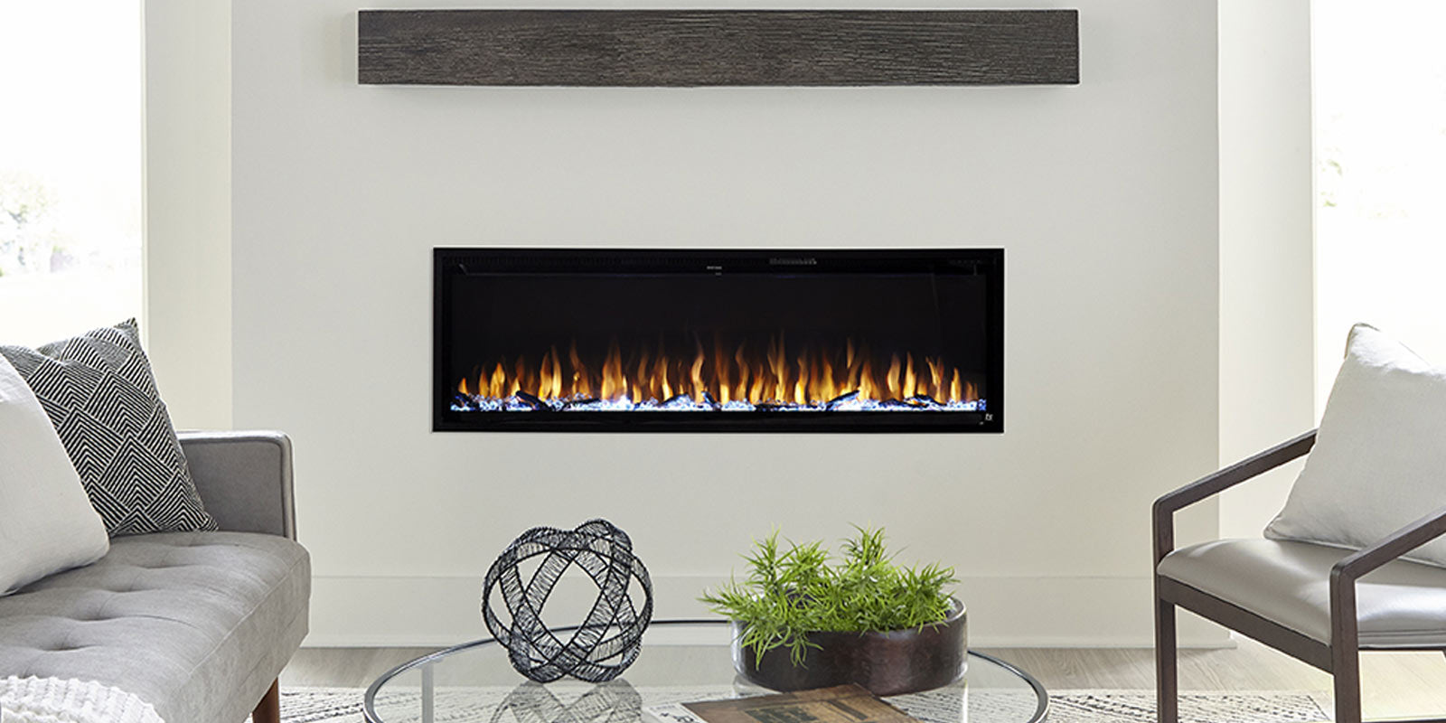 Touchstone Sideline Elite Smart Electric Fireplace in white accent wall with gray couch