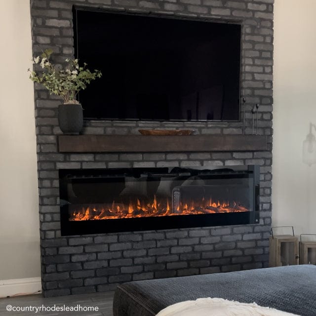 Touchstone Sideline 72 Electric Fireplace inserted in dark gray brick accent wall with dark wood mantel