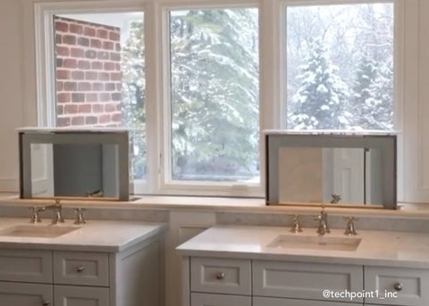 Double bathroom vanities in front of window with motorized mirrors using Touchstone TV Lift Mechanism
