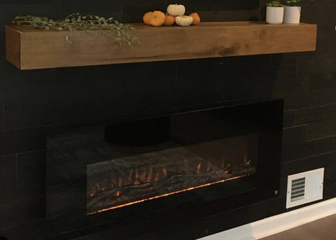 Touchstone Onyx Electric Fireplace mounted on dark gray wall with medium oak mantel