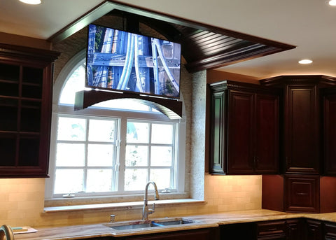 Touchstone Whisper Lift TV lift lowering from the ceiling in front of the kitchen window