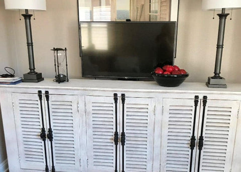 Touchstone Whisper Lift TV Lift mounted on the floor behind the bedroom dresser