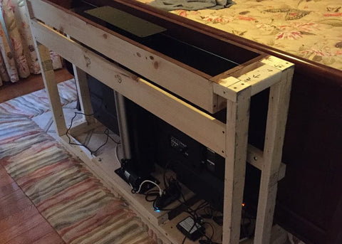 Whisper Lift shown framed in a custom built end of bed tv cabinet