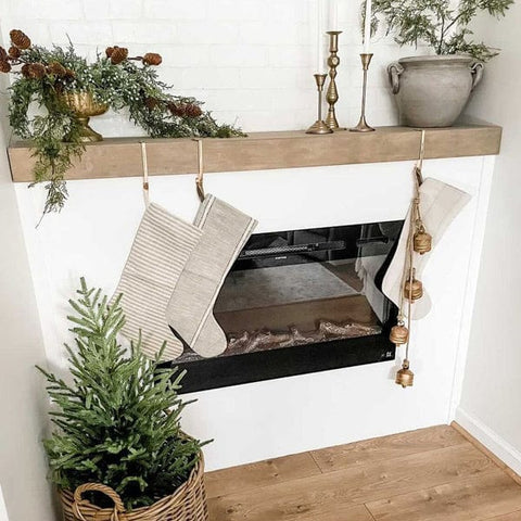 Touchstone Sideline Electric Fireplace in white accent wall with light wood mantel and natural wood floors decorated for Christmas by @athomewithjhackie1