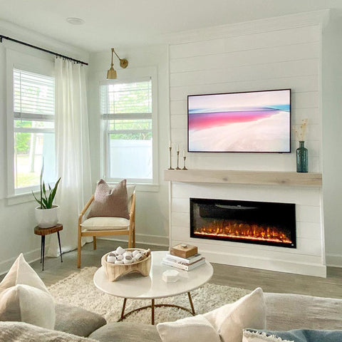 Touchstone Sideline Elite Smart Electric Fireplace in white accent wall with light wood mantel by @nicolelynninteriors