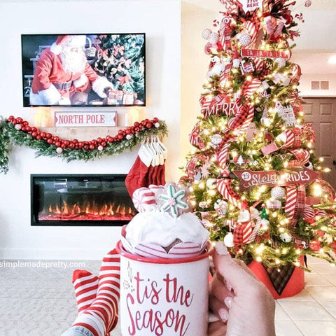 Touchstone Sideline Elite Electric Fireplace with holiday garland in white accent wall by @simplemadepretty