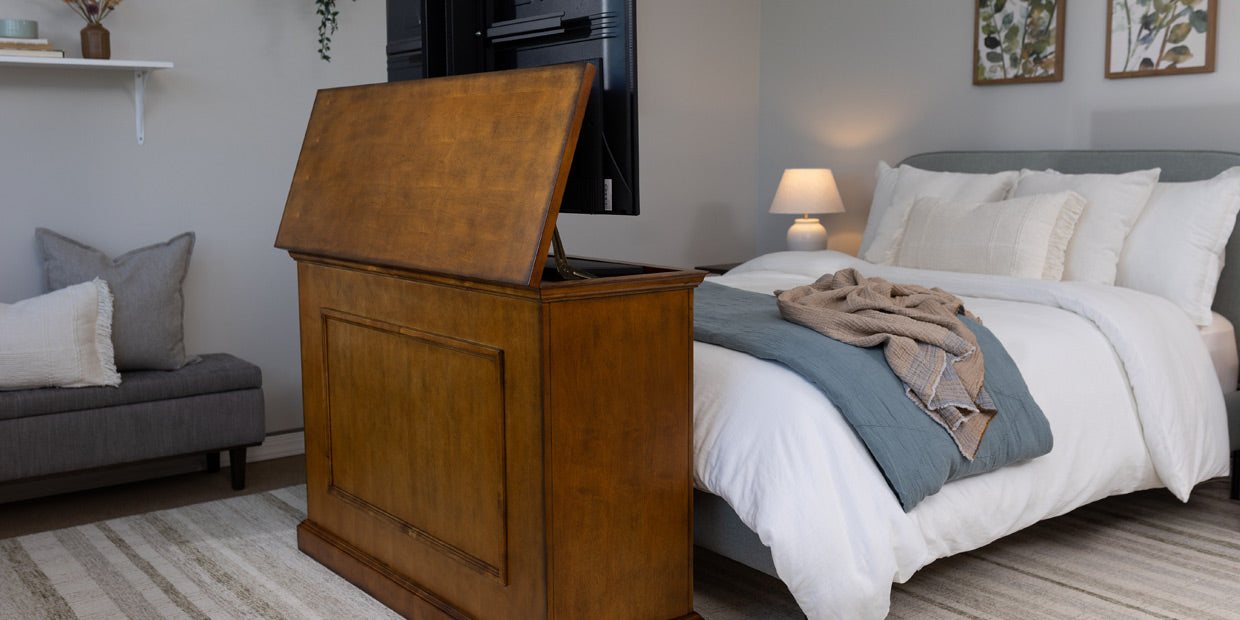 Elevate TV Lift Cabinet in Honey Oak positioned at the end of the bed