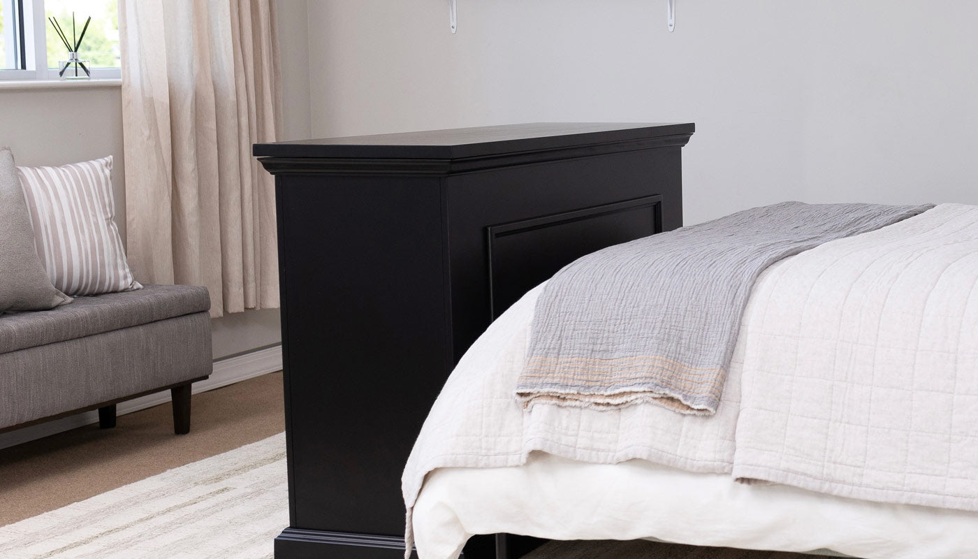 Touchstone Elevate® TV Lift Cabinet in Black wood finish placed at end of bed