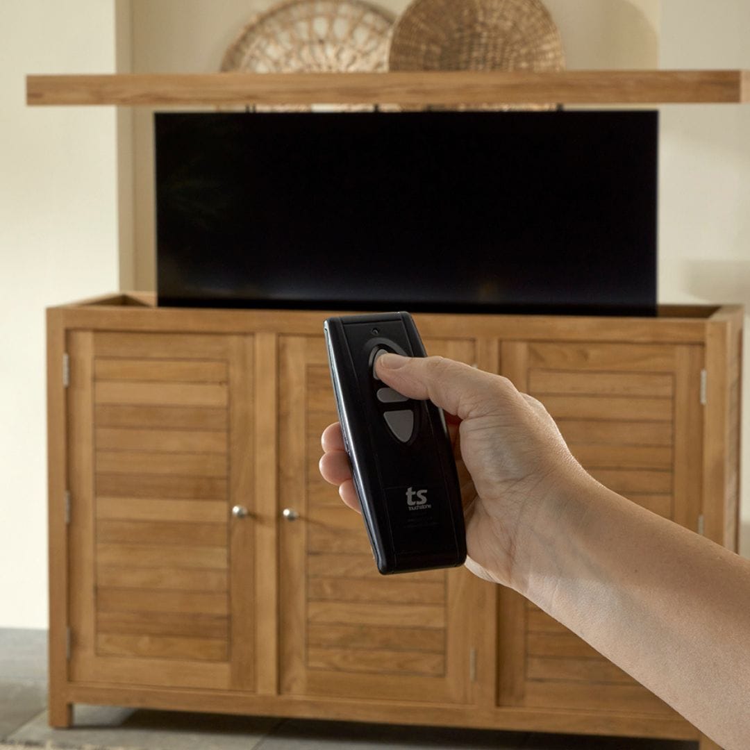 Touchstone TechTeak TV Lift Cabinet lifestyle image showing remote in use.