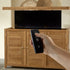 Touchstone TechTeak TV Lift Cabinet lifestyle image showing remote in use.