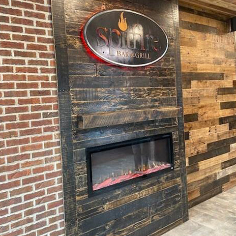 Touchstone Sideline Elite Electric Fireplace in rustic dark wood paneling, in SpitFire Grill