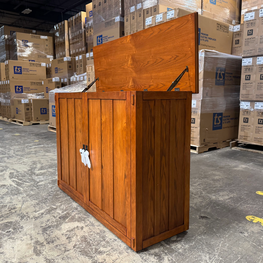 Touchstone Elevate Mission Smart TV Lift Cabinet in a light oak finish photographed in the warehouse - showroom unit.
