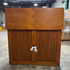Touchstone Elevate Mission Smart TV Lift Cabinet in a light oak finish photographed in the warehouse - showroom unit.