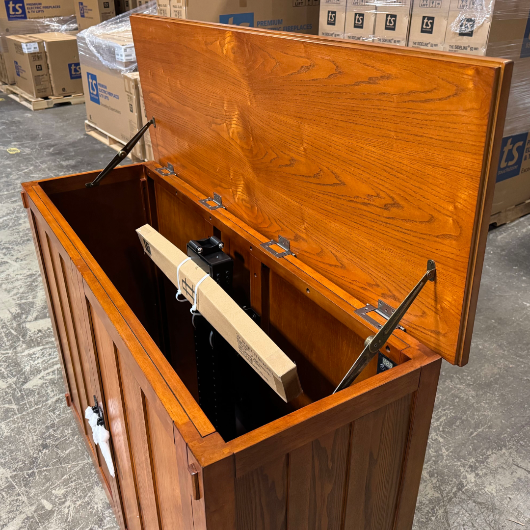 Touchstone Elevate Mission Smart TV Lift Cabinet in a light oak finish photographed in the warehouse - showroom unit.