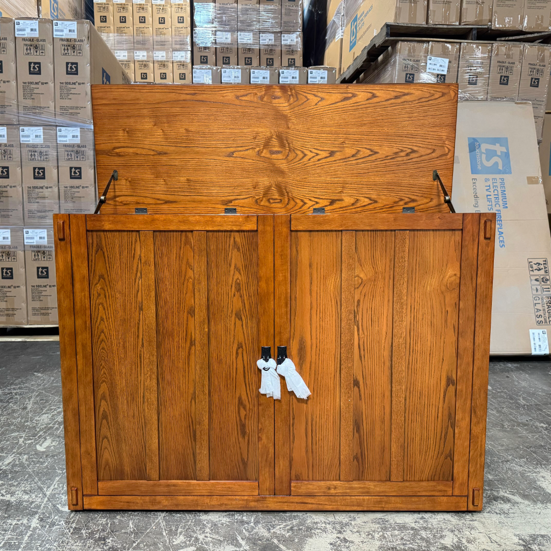 Touchstone Elevate Mission Smart TV Lift Cabinet in a light oak finish photographed in the warehouse - showroom unit.