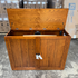 Touchstone Elevate Mission Smart TV Lift Cabinet in a light oak finish photographed in the warehouse - showroom unit.