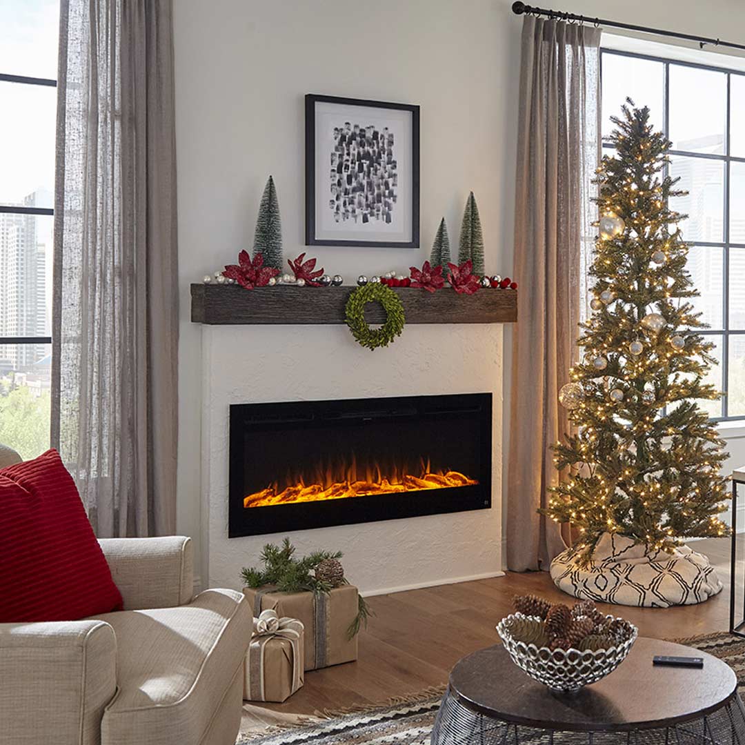Touchstone Sideline Smart Electric Fireplace is inserted in a white accent wall and decorated for the holidays.