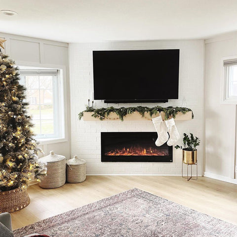 The Sideline® Electric Fireplace in a corner wall in white accent with light wood mantel by @benandlacedesign