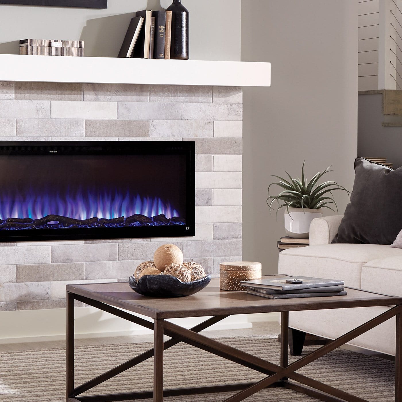Touchstone Sideline Elite in a white brick fireplace mantel with blue flames and logs