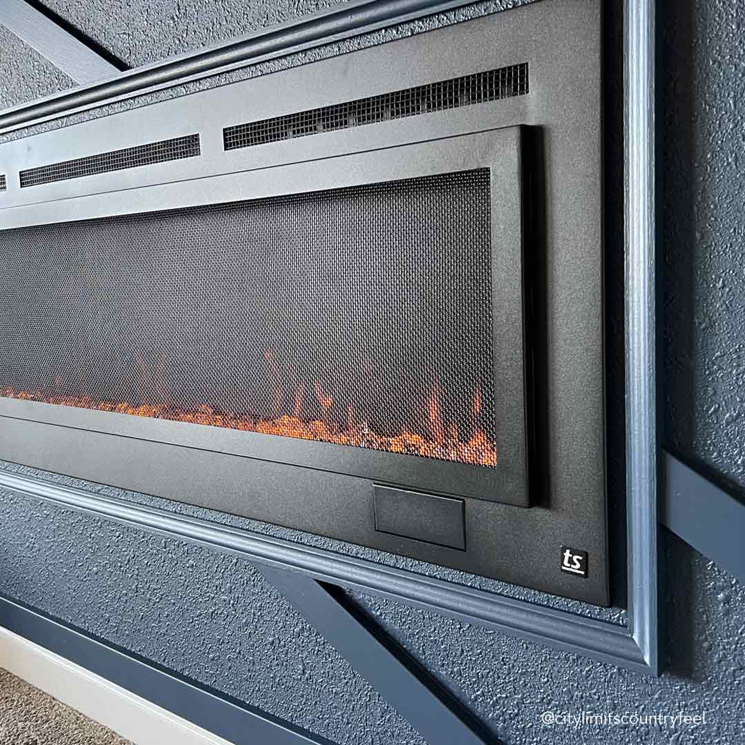 Touchstone Sideline Steel 60 inch Electric Fireplace closeup of mesh screen in board and battan accent wall by @citylimitscountryfeel