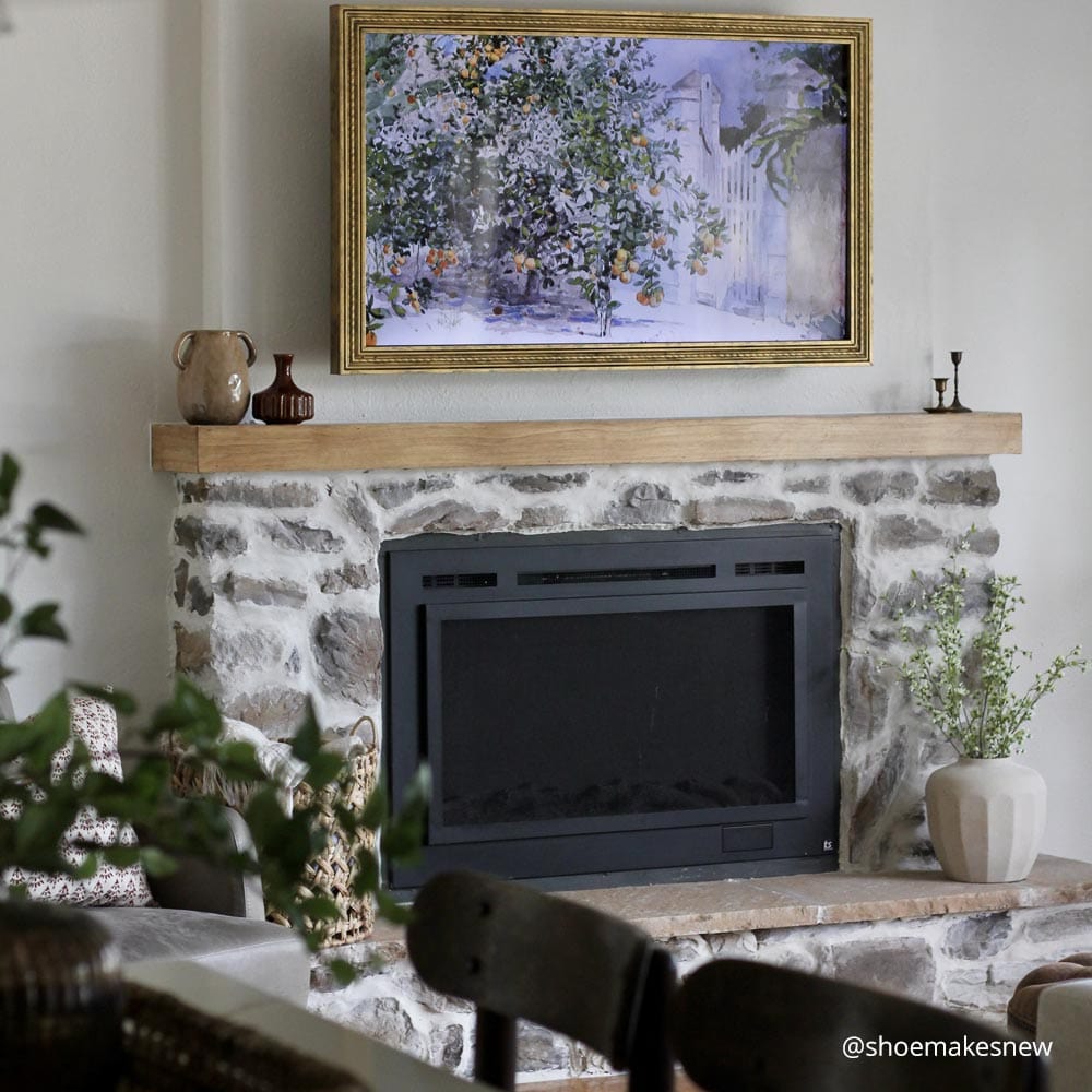 Touchstone Sideline Forte Electric Fireplace installed in DIY stone fireplace wall with natural wood mantel