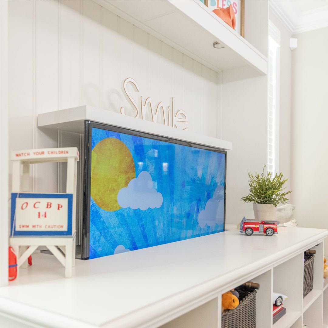 Touchstone motorized TV lift is installed in playroom accent wall with storage bins and hidden TV