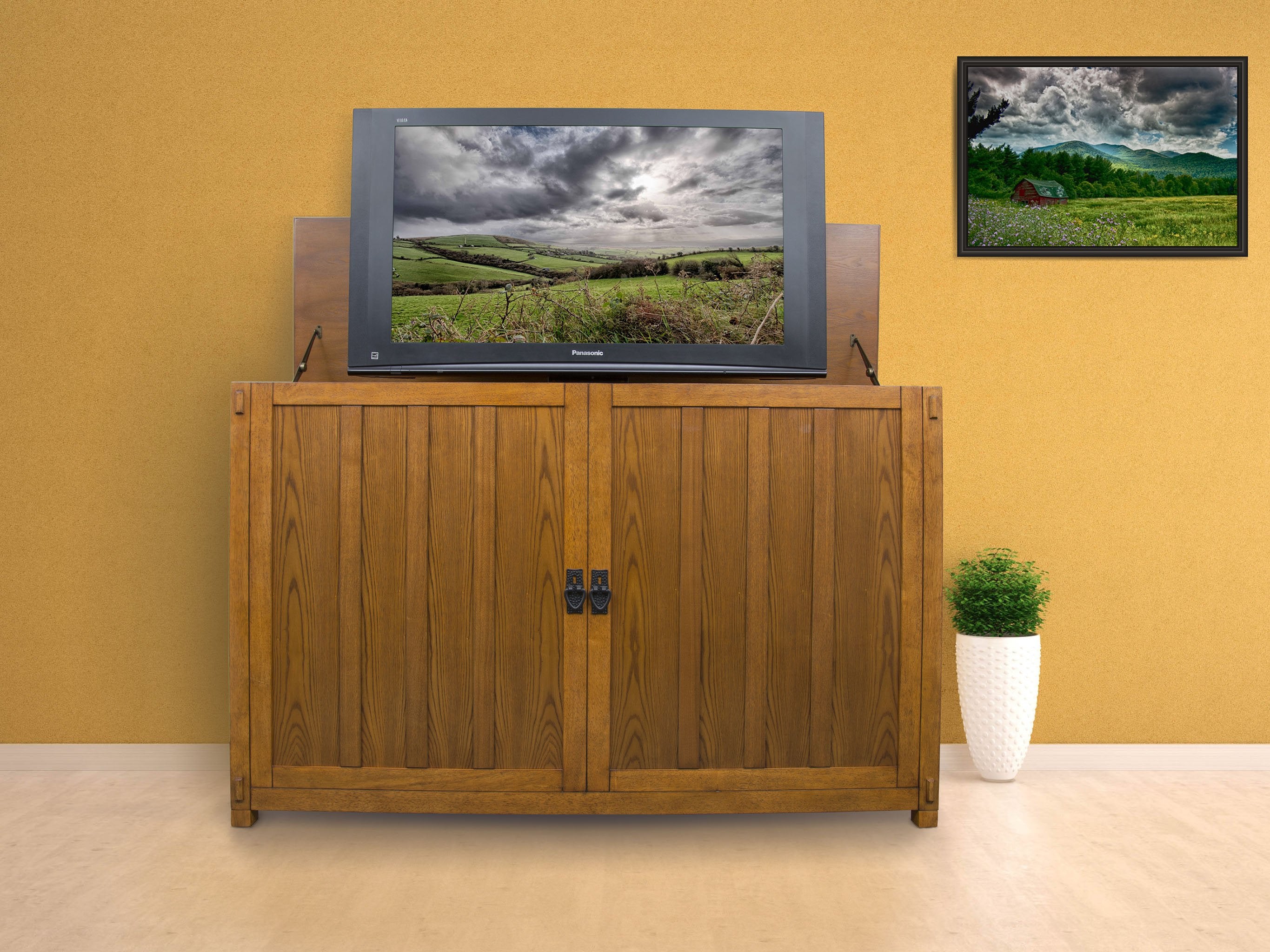 Grand Elevate 74006 Mission TV Lift Cabinet for 65 inch Flat screen TVs pictured in a room.